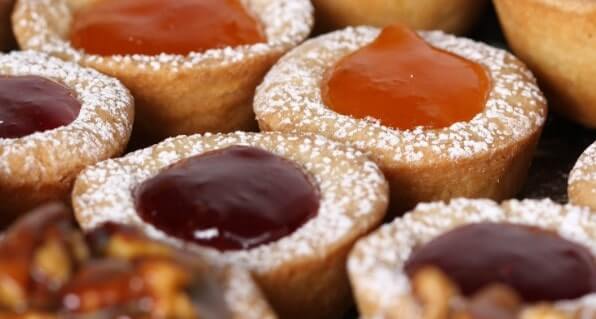 Jam tarts with a dusting of icing sugar freshly baked after being baked in a pizza oven.