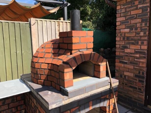 A Naples 600 Pizza Oven sitting outside a family’s garden ready for their evening dinner.
