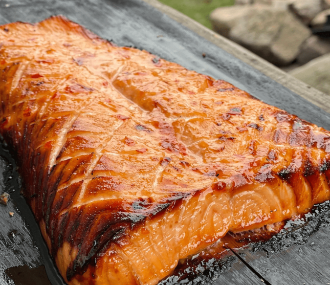 A juicy salmon steak that has been perfectly cooked in a wood fired pizza oven being used in the correct way.